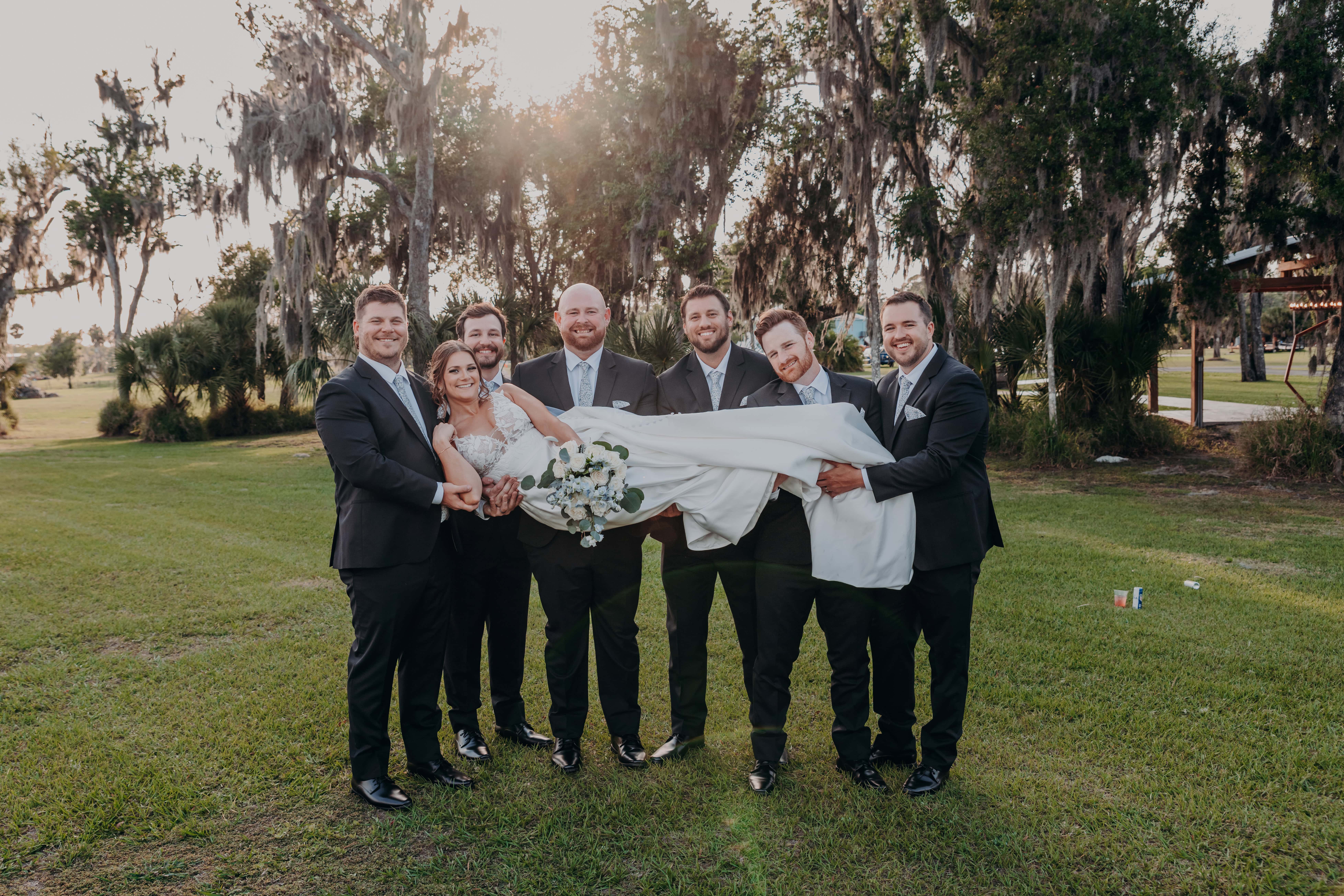 Hidden Acres wedding groomsmen lifting bride Hannah at golden hour