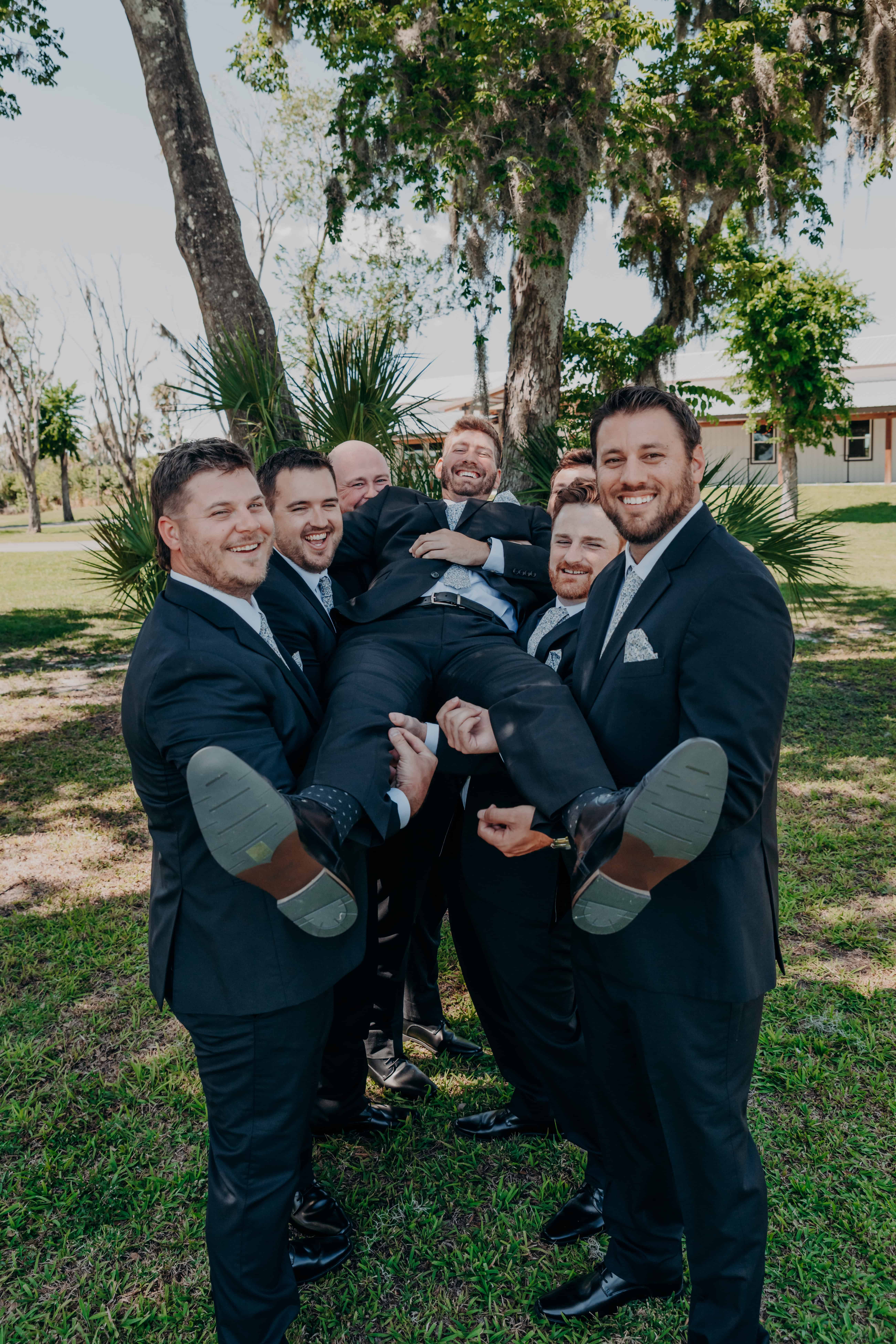 Hidden Acres wedding groomsmen lifting groom Sean celebration