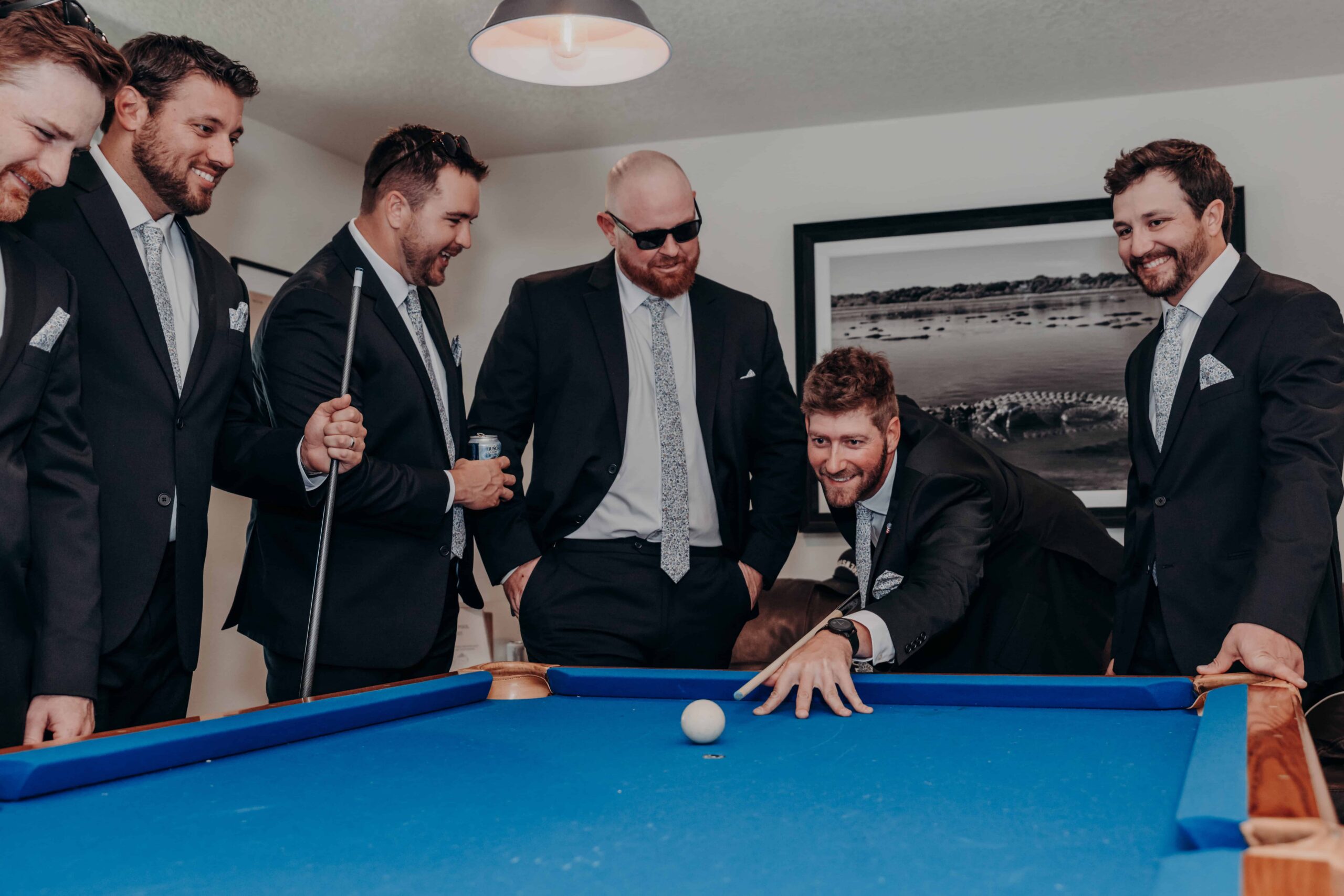 Hidden Acres wedding groomsmen in suits at pool table getting ready