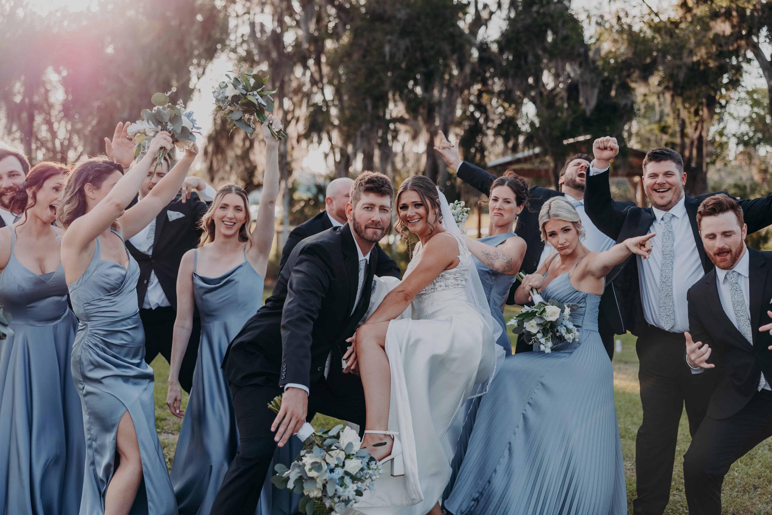 Hidden Acres wedding party groom carrying bride in celebration