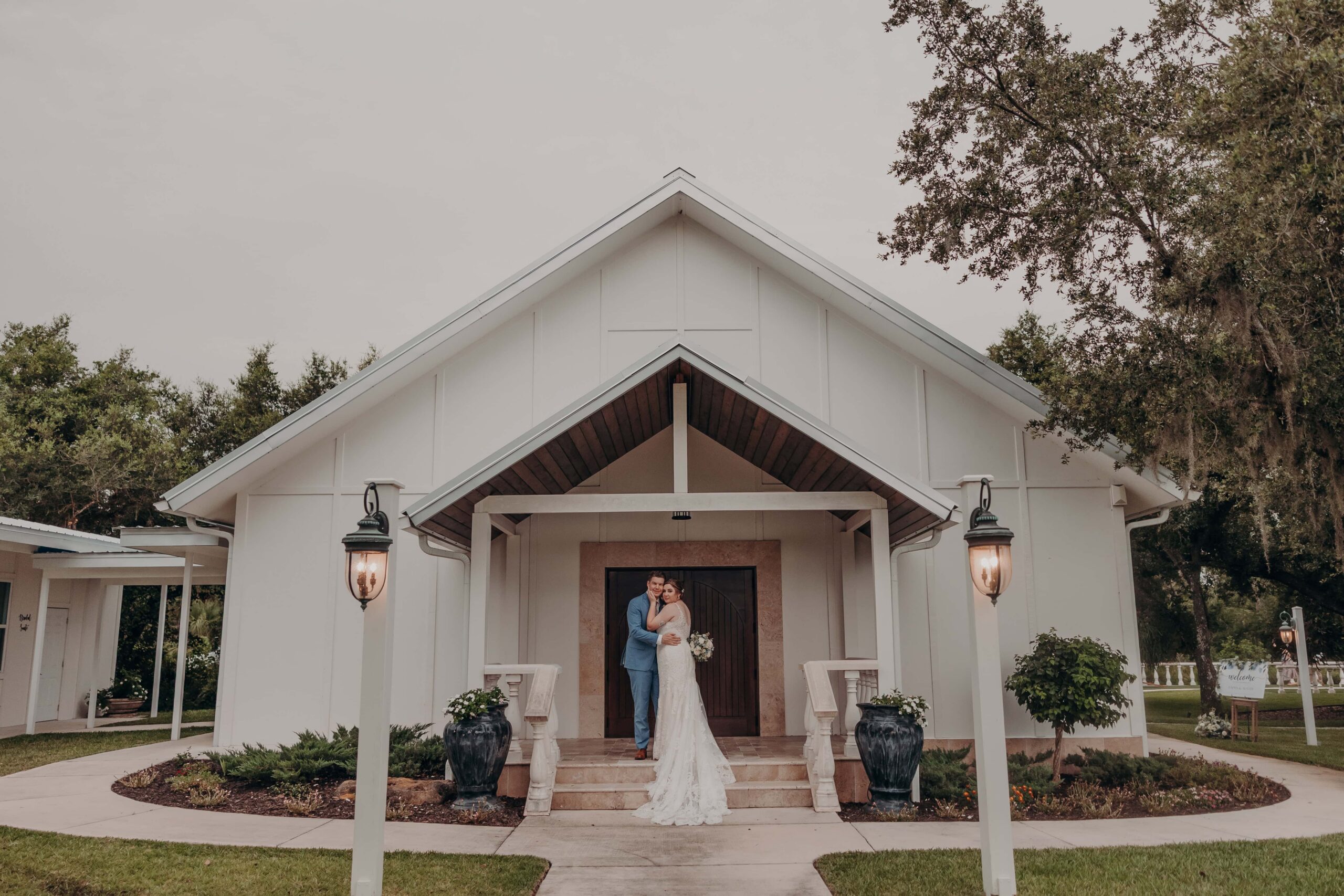Couple in front of Hudson Manor chapel-style venue exterior at Diamond C Ranch Myakka City Florida