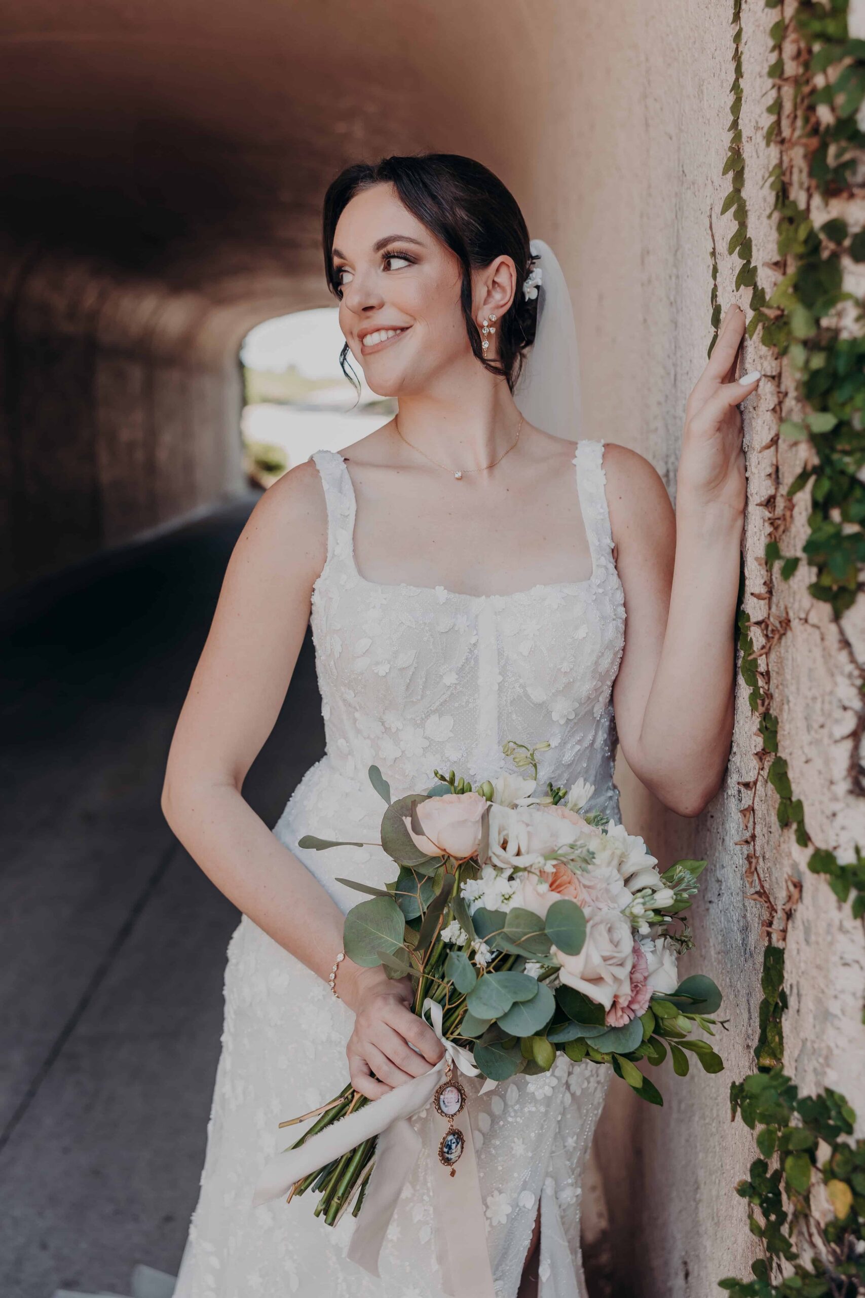 Natural groom portrait of Ryan adjusting his tie in the ivy tunnel at Lakewood Ranch Golf and Country Club photographed by Angela Moon Photography