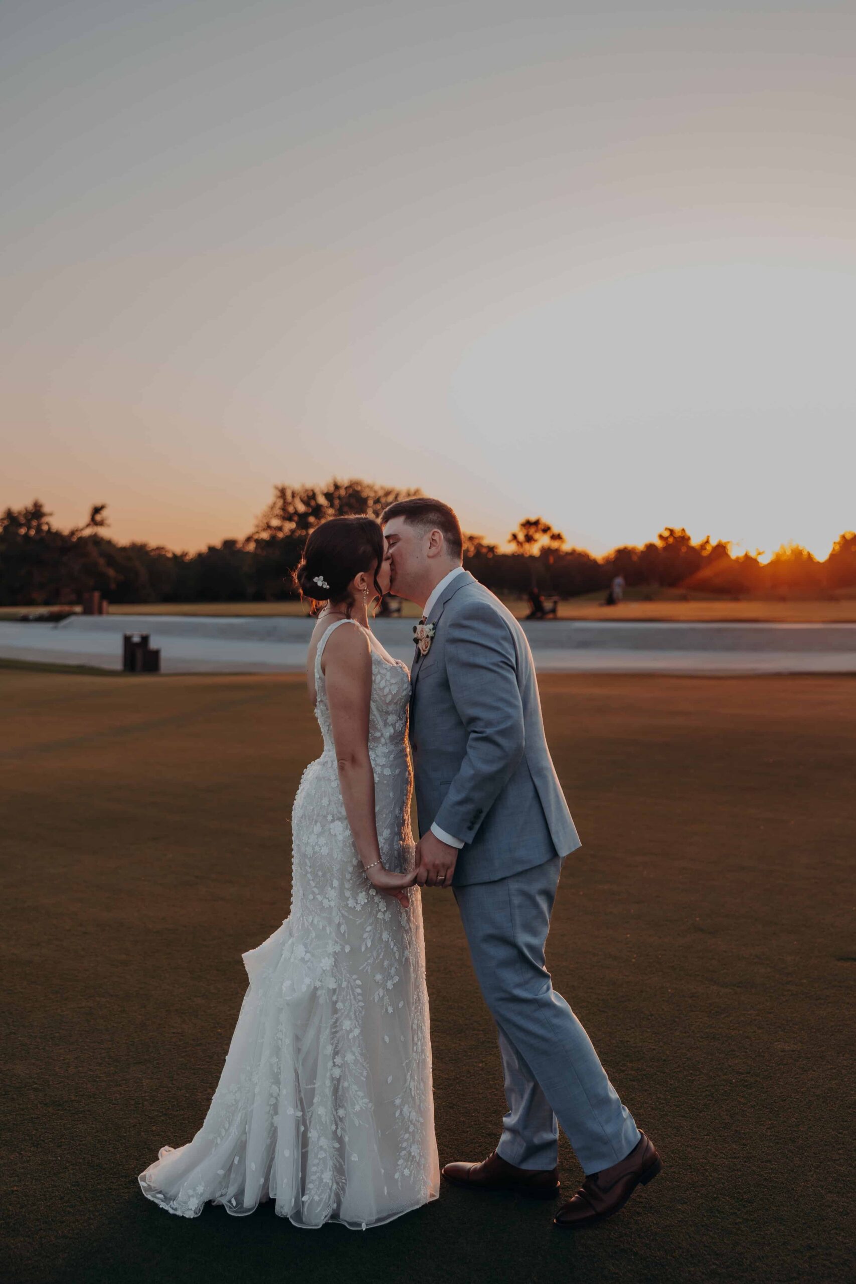 Romantic sunset portrait of Brianna and Ryan Whitley on the golf course at Lakewood Ranch Golf and Country Club as the sun sets over the water