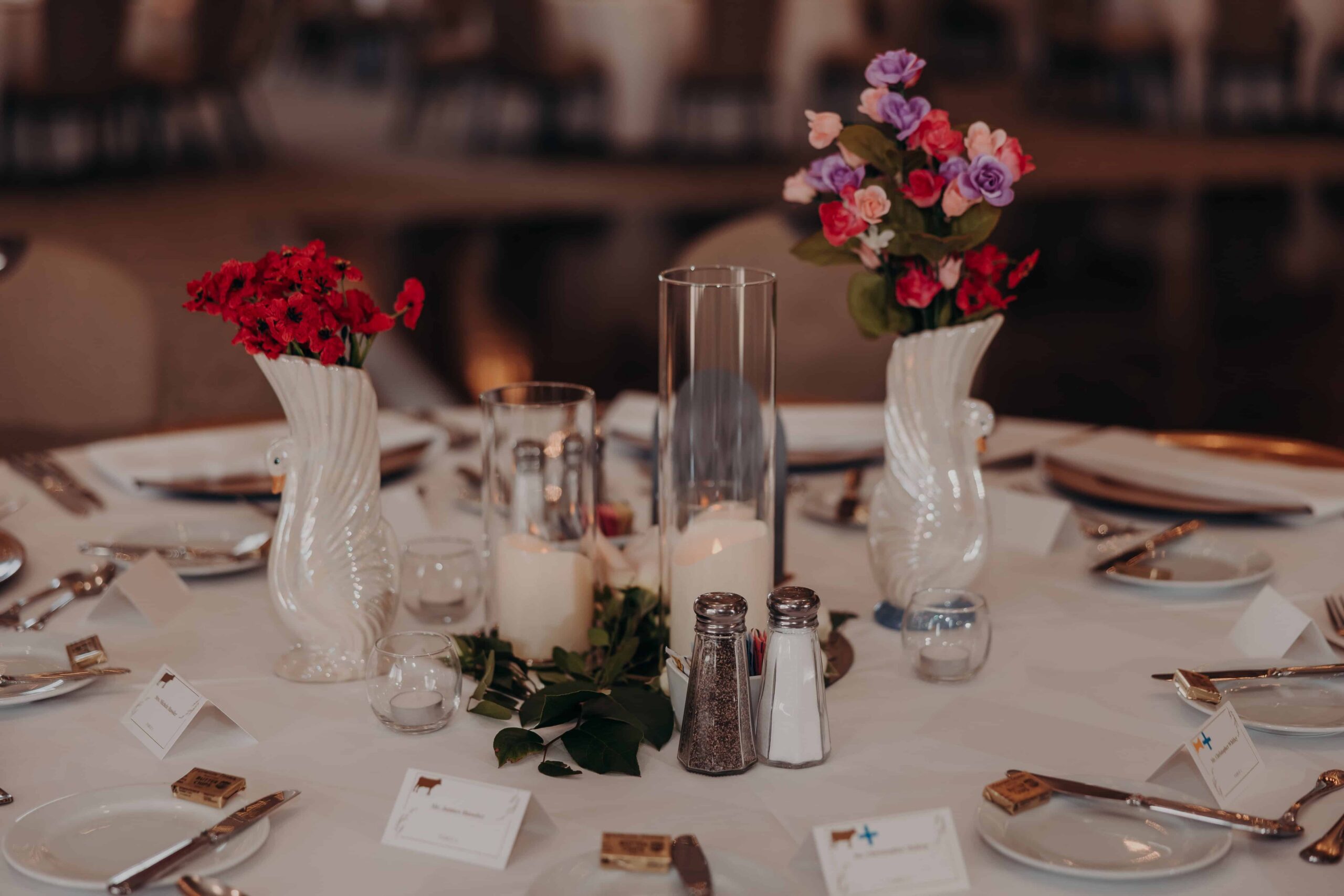 Sweetheart table with white backdrop gold lanterns and trailing greenery designed by Swanky Soiree at Lakewood Ranch Golf and Country Club reception