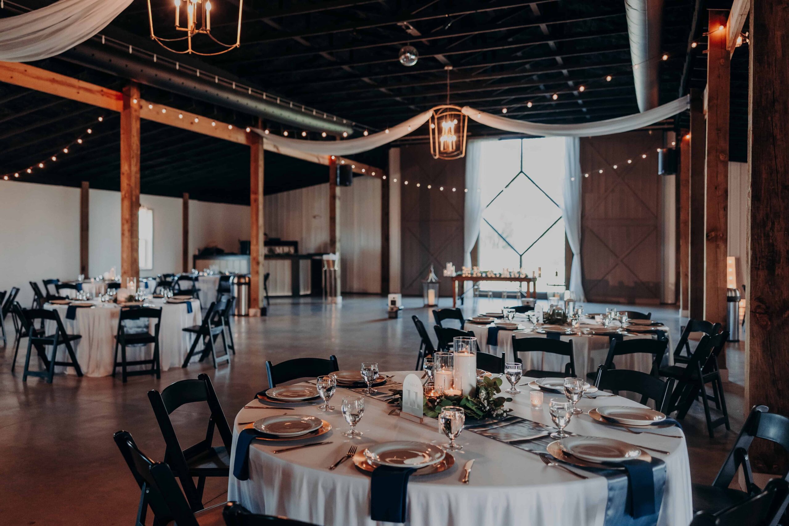 The Venue at Hidden Acres reception barn interior with tables set for dinner