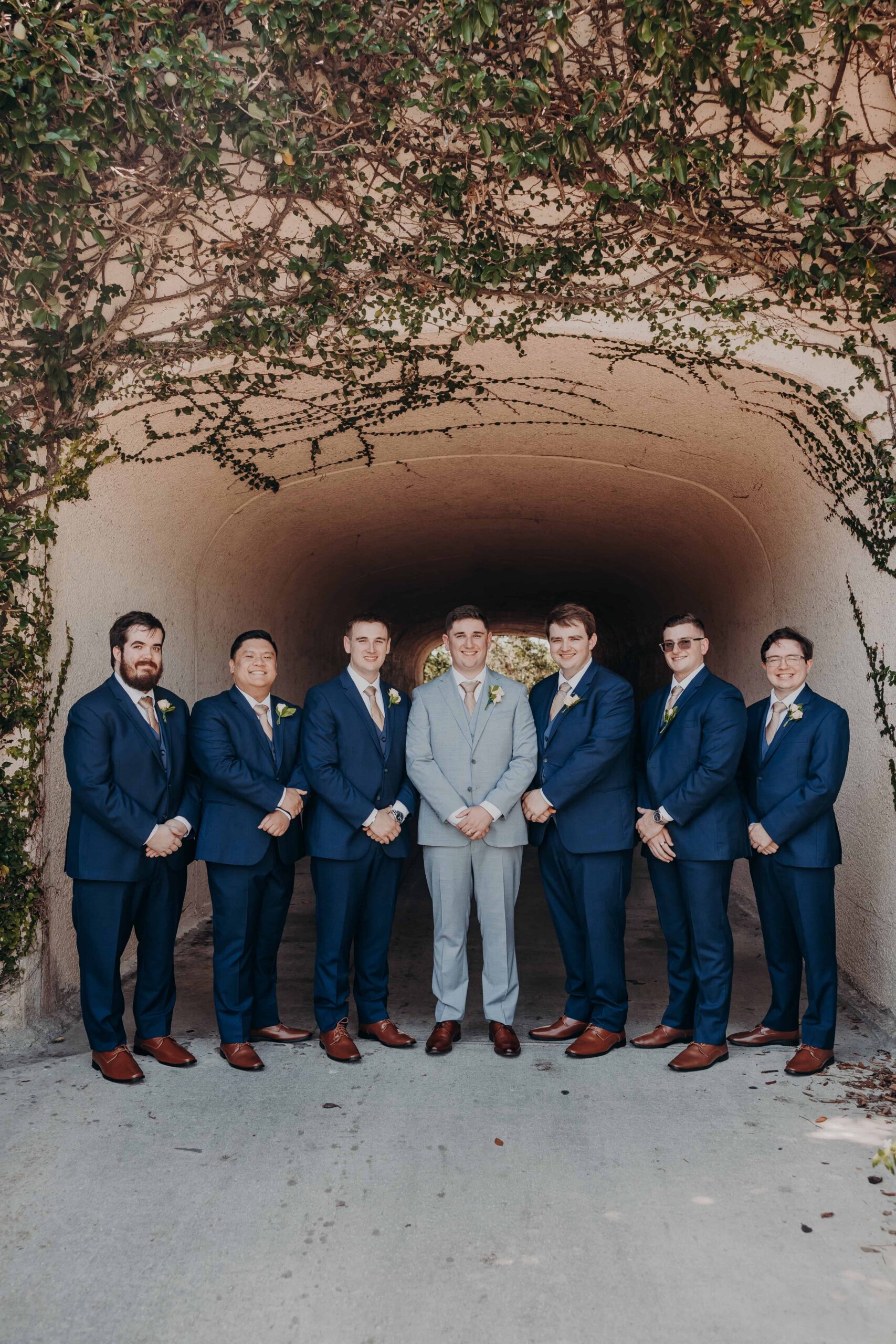 Wedding party portrait with seven bridesmaids in champagne satin and six groomsmen in navy at Lakewood Ranch Golf and Country Club