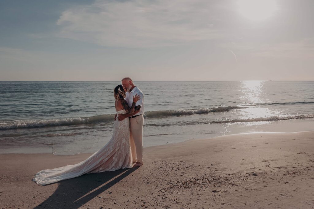 Wide shot of Sarah and Jasen walking together on Siesta Key beach at golden hour