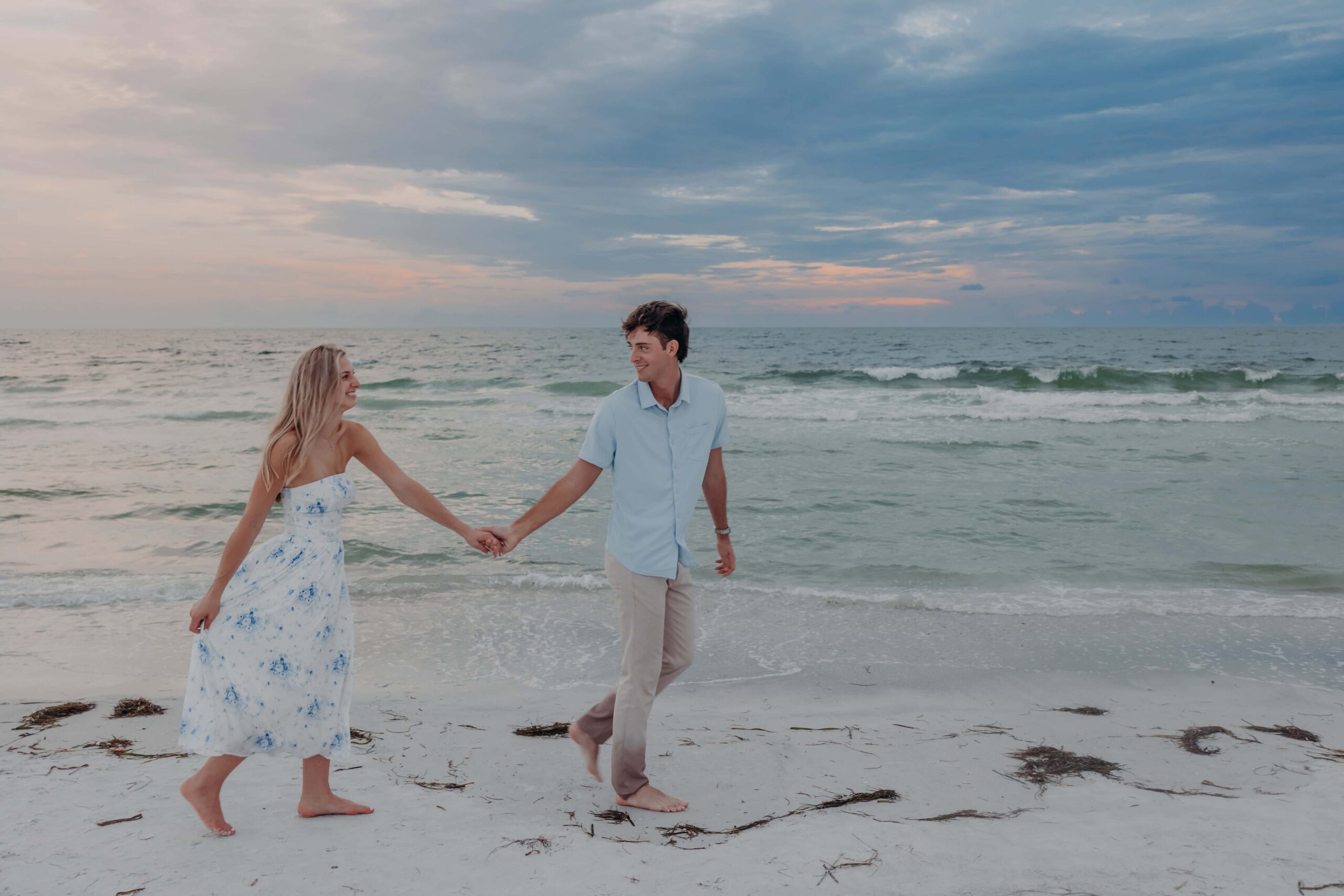 Quinten and Suzanna walking hand in hand at sunset on Lido Beach, Sarasota
