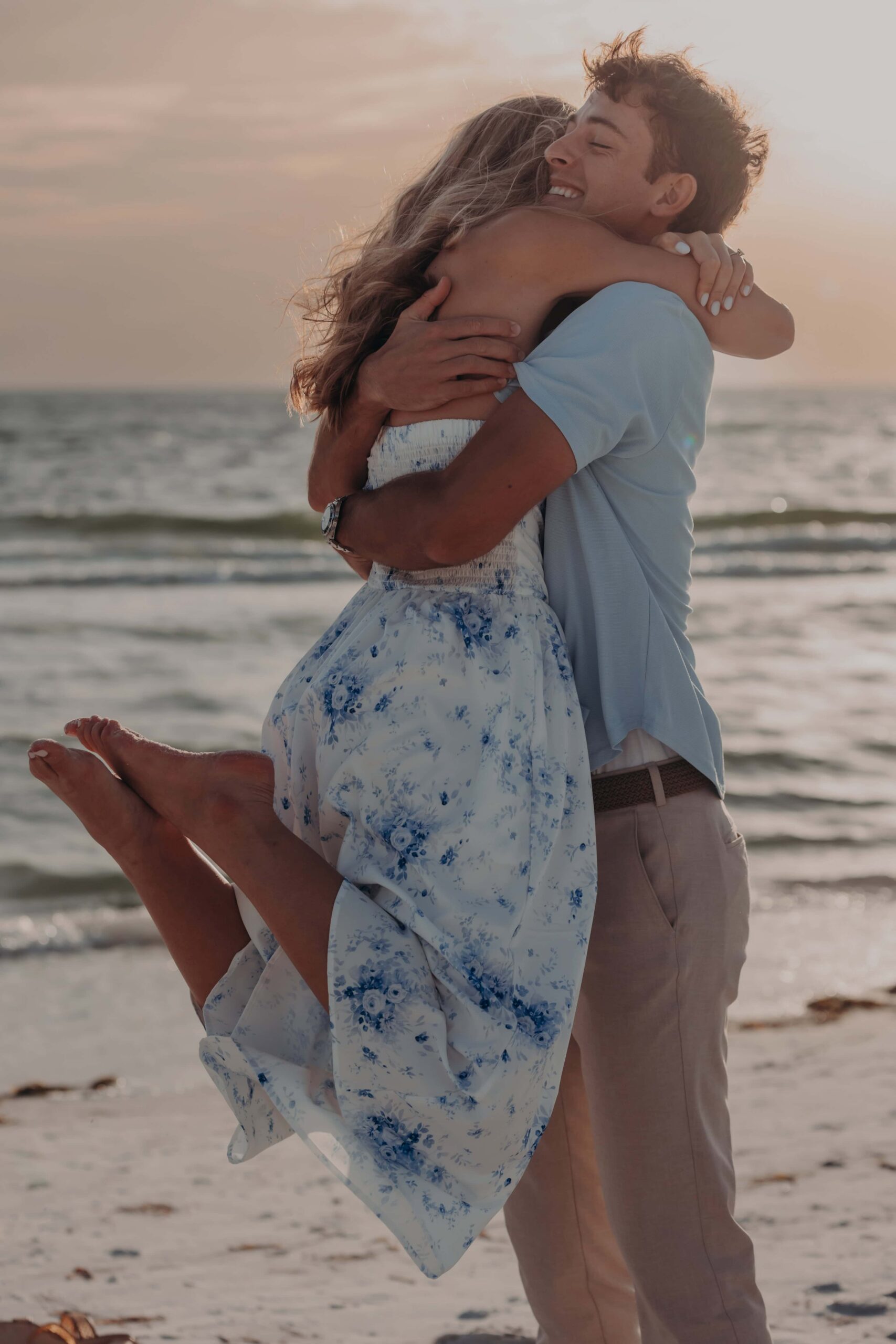 Quinten lifting Suzanna during their Lido Beach proposal session in Sarasota