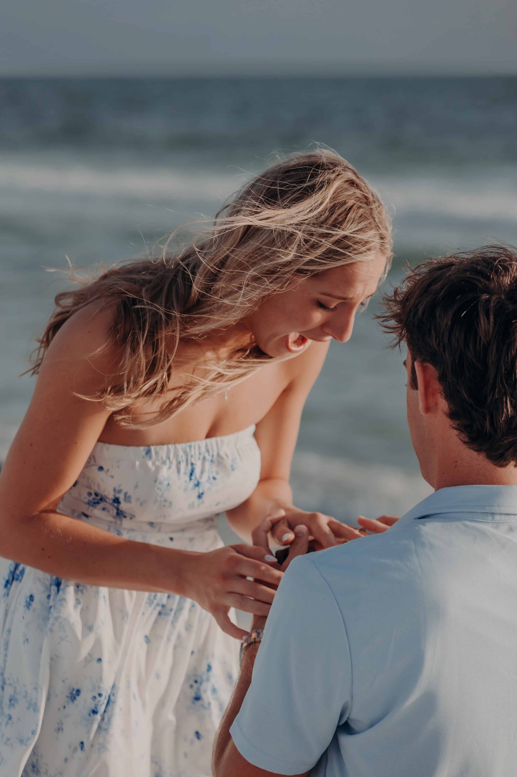 Quinten placing the engagement ring on Suzanna's finger at Lido Beach, Sarasota