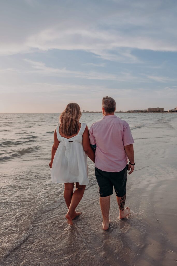 siesta key beach proposal couple walking toward horizon sunset sarasota