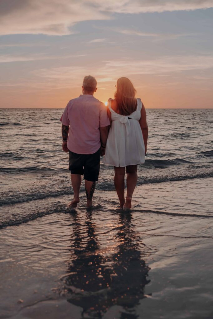siesta key beach proposal couple walking toward sunset reflection sarasota
