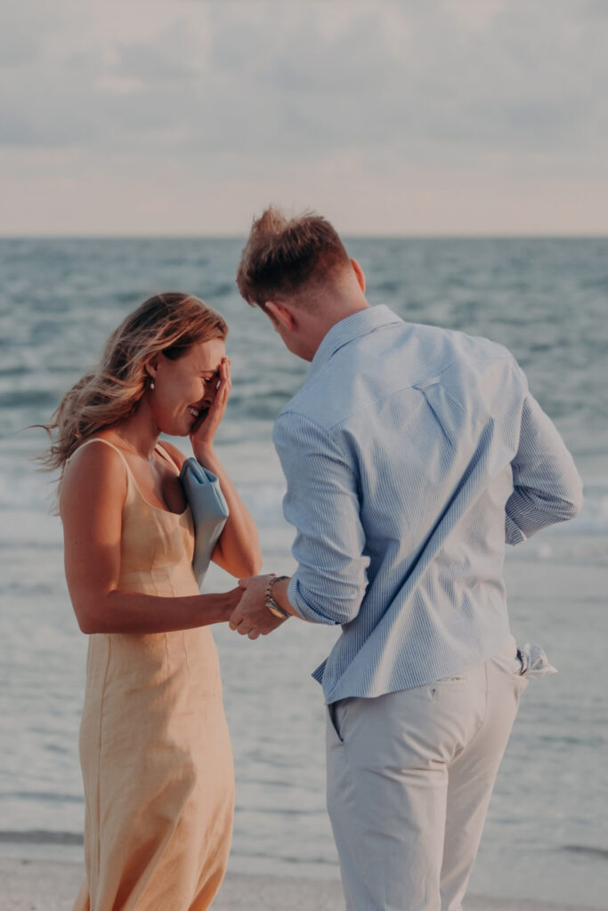 Regan in her yellow dress laughing with Michael on the beach