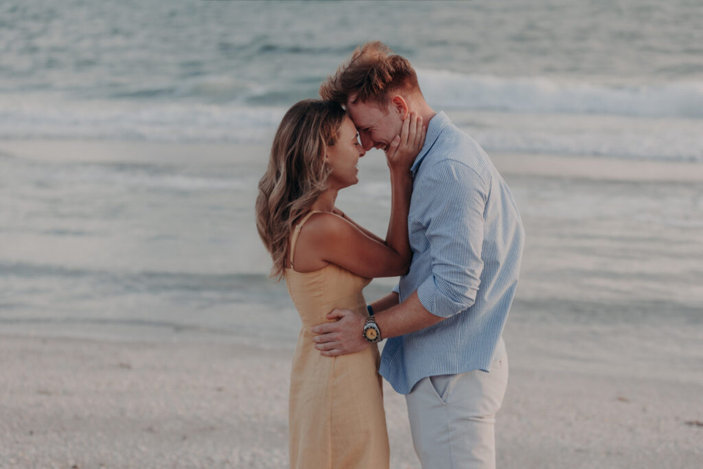 Michael and Regan walk hand in hand along the beach on Longboat Key