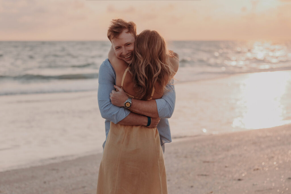 Regan in her yellow dress laughing with Michael on the beach
