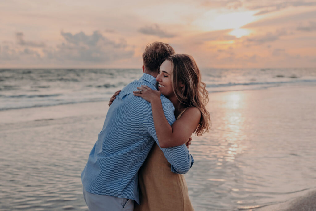 Michael and Regan walking together on the sand at sunset