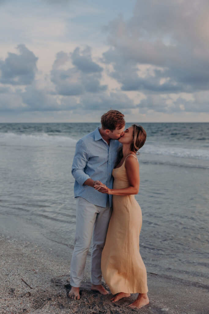 Michael and Regan walk hand in hand along the beach on Longboat Key