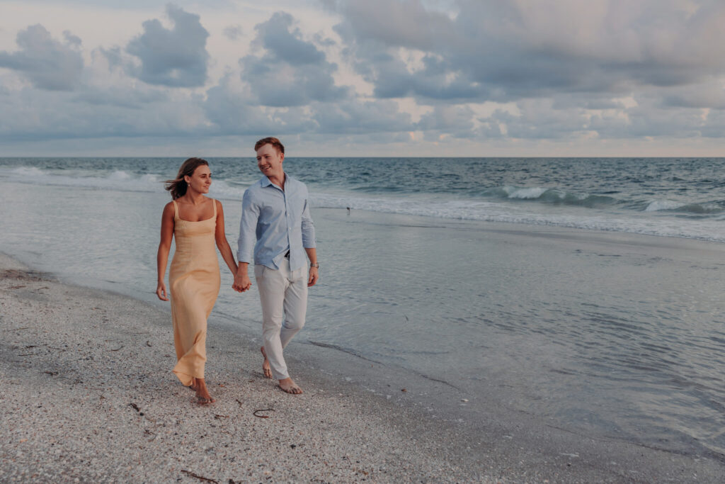 Michael and Regan embrace at sunset following their surprise beach proposal