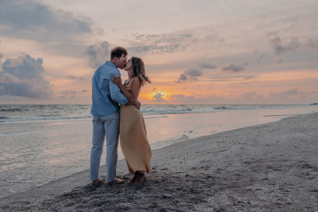 Michael and Regan walking together on the sand at sunset