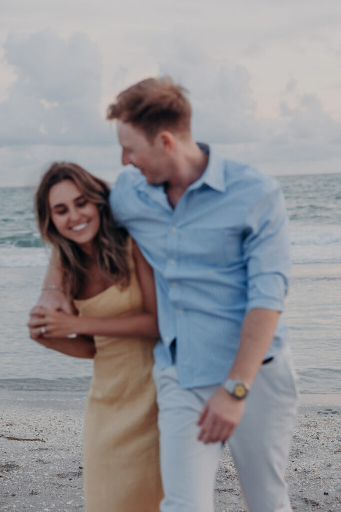 Michael and Regan walk hand in hand along the beach on Longboat Key